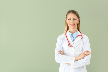 Female doctor with stethoscope on color background
