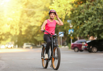 Sporty young woman riding bicycle outdoors