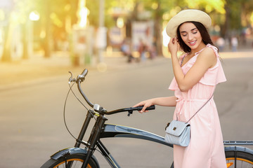 Obraz premium Smiling Young Woman with Bicycle and Hat on Sunny Day