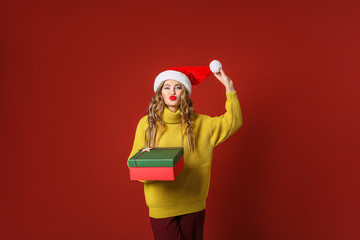 Beautiful young woman with Christmas gift on color background