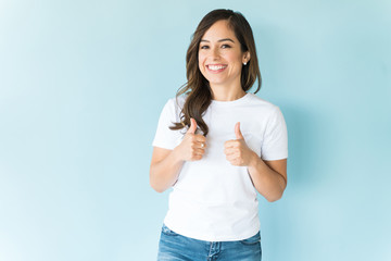 Woman Giving Thumbs Up Over Blue Background