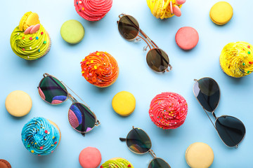 Composition with stylish sunglasses and treats on color background