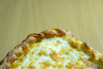 Freshly baked khachapuri with cheese on a wooden board.