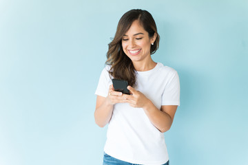 Smiling Woman Texting And Using Smartphone On Colored Background