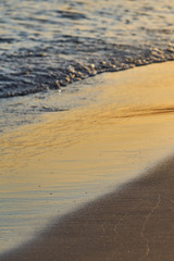                          Sandy beach with blurred sea water on a sunset as a natural background. Copy space.      