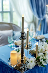 Wedding table decorated with white flowers, candles..Blue and white.