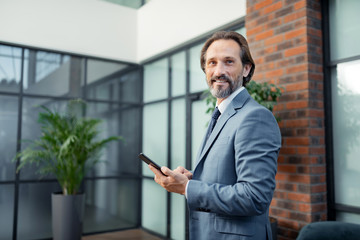Bearded businessman standing in his modern spacious office