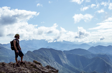 boy alone on a mountain looking at the horizon