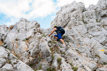 red-haired boy climbing a mountain from behind