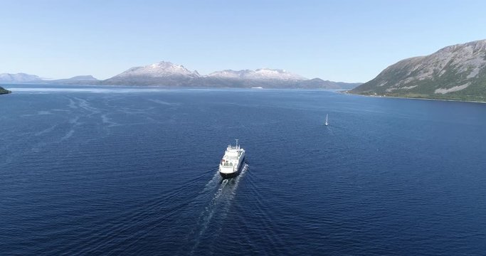 NORWAY, HANSNES - AUGUST 3, 2019 - Aerial footage of ferry sailing from Hansnes to Vannøya in Karlsøy municipality near Tromsø