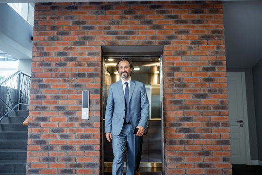 Grey-haired businessman wearing suit and tie feeling motivated