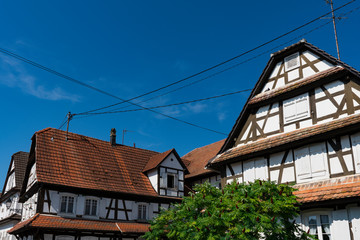 white half timbered house with shutters and orange roof tiles. Hunspach, France
