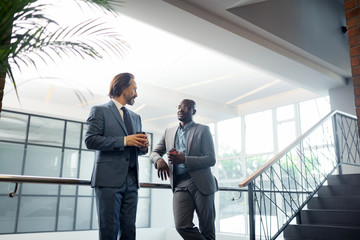 Bearded businessman speaking with partner and having coffee time