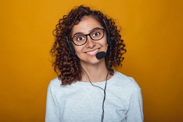 Portrait of a joyful Indian girl call center employee in headphones and glasses. Smile friendly...
