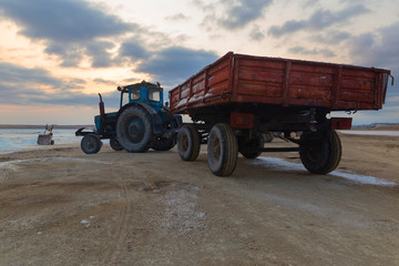 Obraz premium Tractor with a trailer delivering mined salt from a salt lake
