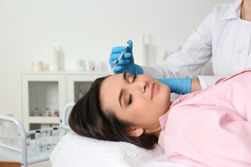 Young woman with hair loss problem receiving injection in salon