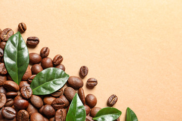 Fresh green coffee leaves and beans on light orange background, flat lay. Space for text