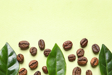 Fresh green coffee leaves and beans on light green background, flat lay. Space for text