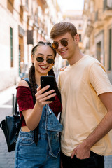 Happy young couple using mobile phone