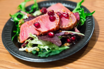 Tuna sashimi with salad mix and pomegranate