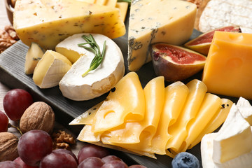 Composition with different delicious cheeses and fruits, closeup