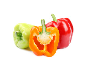 Whole and cut bell peppers on white background