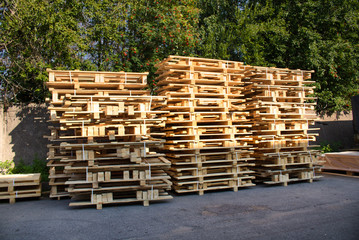 Wooden pallets stacked on top of each other in an open warehouse. Industrial materials of woodworking production.