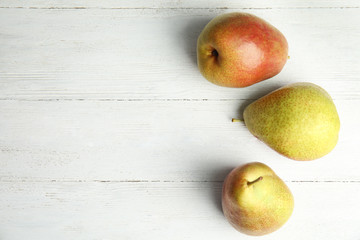 Ripe juicy pears on white wooden table, top view. Space for text