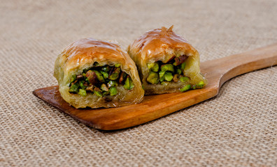 Turkish dessert piece of baklava on wooden spoon