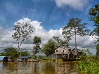 Balsas y casas en el río Ucayali un día soleado Peru