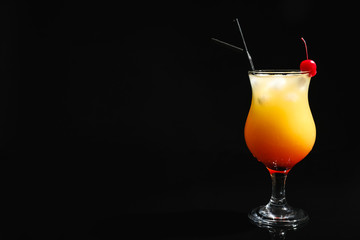 Glass of cocktail Sex on the Beach, black background. Space for text