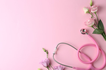 Flat lay composition with stethoscope and flowers on pink background, space for text. World health...