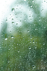 View from window on spring rainy day. Beautiful view at dim green outlines nature backdrop. Water...