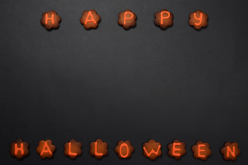 The hand-made eatable gingerbread Halloween inscription on black background