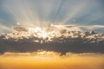 Very beautiful sunset at the sea. The sun's rays pass through the cloud.