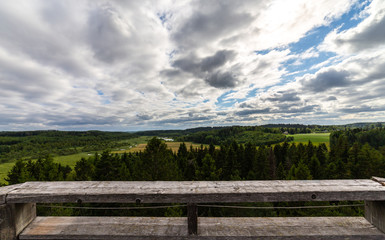 Fototapeta na wymiar Panorama photo of finnish countryside with dramatic clouds. Bright summer weather with vibrant colors.