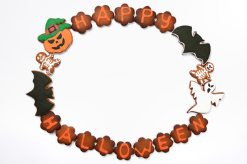 The hand-made eatable gingerbread Halloween inscription, pumpkin, ghosts and sceletons on white background