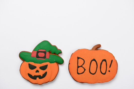 The hand-made eatable gingerbread Halloween pumpkins with boo inscription on white background