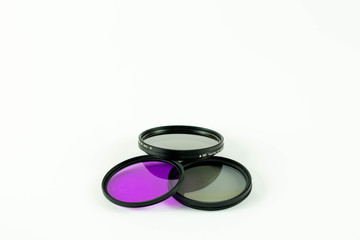 Tres fltros circulares para fotografia apilados sobre fondo blanco.