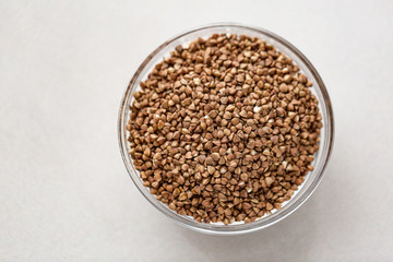 Bowl of buckwheat isolated on white background. Top view.