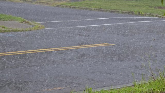Rain water drops falling into puddle on asphalt, flooding the road floods due to the heavy rain in wet season in rain.