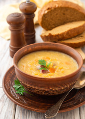 Split pea soup in ceramic bowl on wooden table. Selective focus.