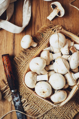 Fototapeta na wymiar champignons, mushrooms in a wooden eco basket on a wooden background
