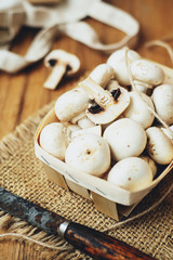 champignons, mushrooms in a wooden eco basket on a wooden background