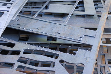 Perforated metal sheets after laser cutting lie on each other. Metalworking waste prepared for recycling.
