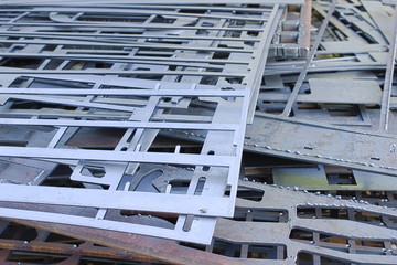 Perforated metal sheets after laser cutting lie on each other. Metalworking waste prepared for recycling.