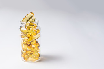 Cod liver oil omega 3 capsules with vitamin E on white background close up, copy space for your...