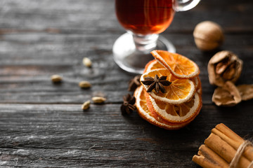 holiday atmosphere, home coziness and comfort, slices of orange lie on the table, a glass of wine