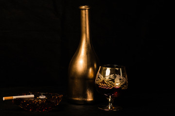 bottle and wine glass photographed on black background