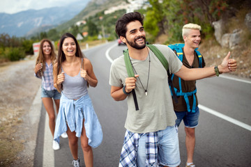 Group of friends backpackers walking and traveling outdoor